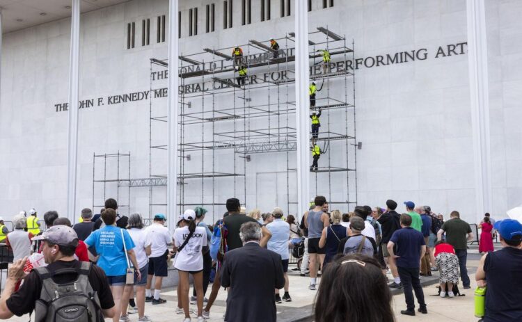 Los espectadores observan cómo los trabajadores se preparan para retirar el nombre del presidente estadounidense, Donald J. Trump, de la fachada del Centro John F. Kennedy para las Artes Escénicas en Washington, DC, EE. UU., el 12 de junio de 2026. EFE/EPA/JIM LO SCALZO
