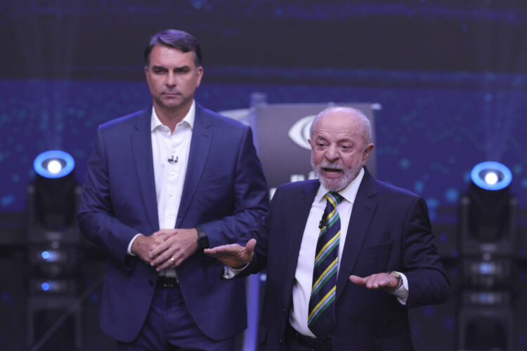AME7366. SAO PAULO (BRASIL), 18/10/2026.- El presidente de Brasil y candidato a la reelección, Luiz Inácio Lula da Silva (d), y el opositor Flávio Bolsonaro, hablan en el primer debate presidencial este domingo, en la sede de Rede Bandeirantes en Sao Paulo (Brasil). Lula atacó a Bolsonaro vinculándolo a los mandatarios de Argentina, Javier Milei, y de EE.UU., Donald Trump, por su parte, el opositor respondió relacionando a su adversario con el jefe de Estado nicaragüense, Daniel Ortega, y con el depuesto presidente venezolano Nicolás Maduro. EFE/ Sebastiao Moreira